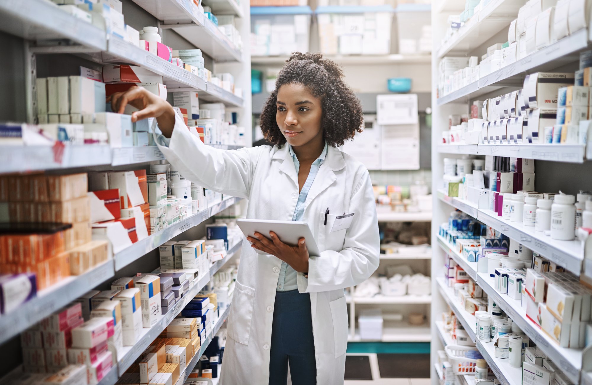 Pharmacist_in_Stockroom_Holding_Tablet