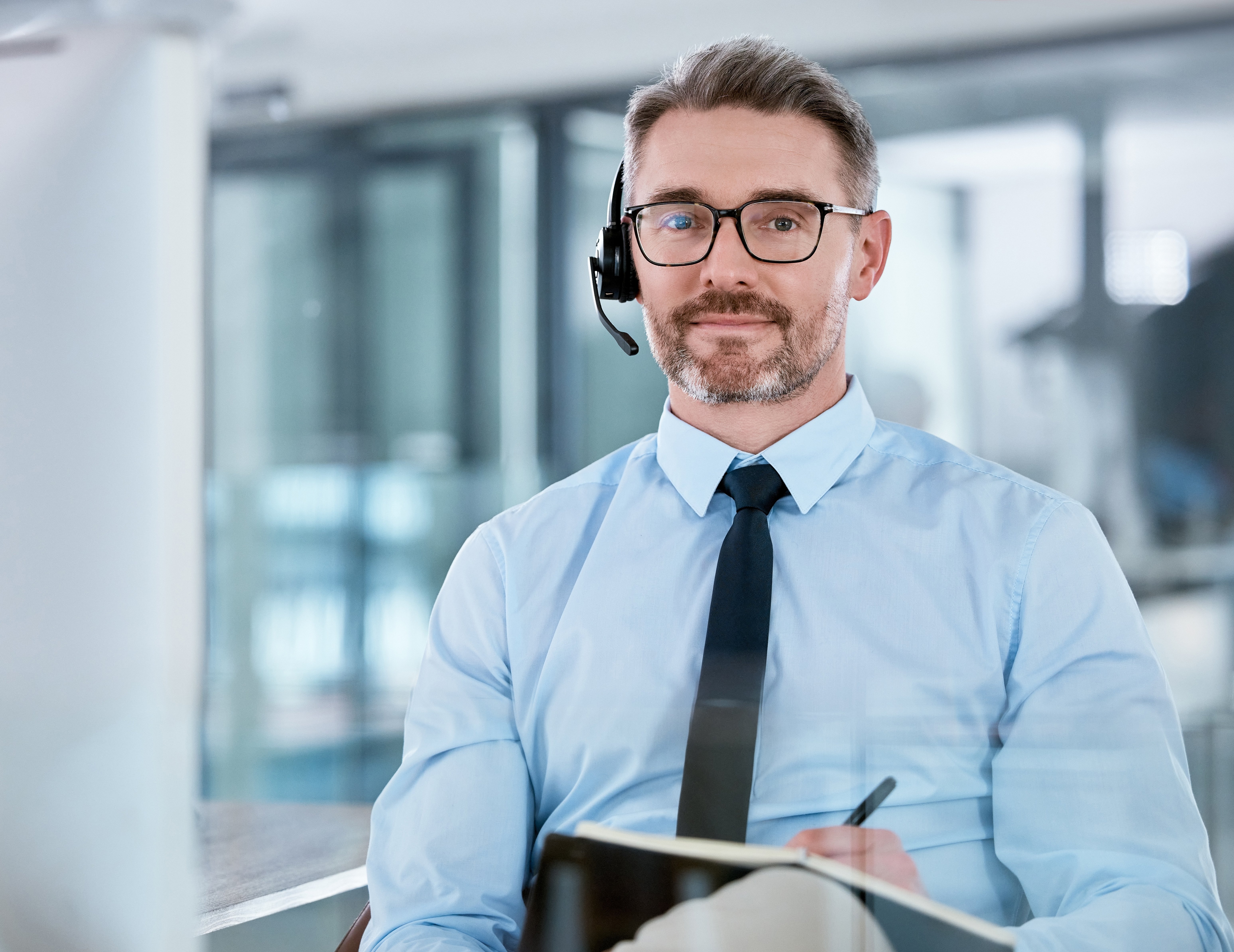 Sales_Rep_wearing_collared_shirt_and_tie_with_notepad_in_his_lap