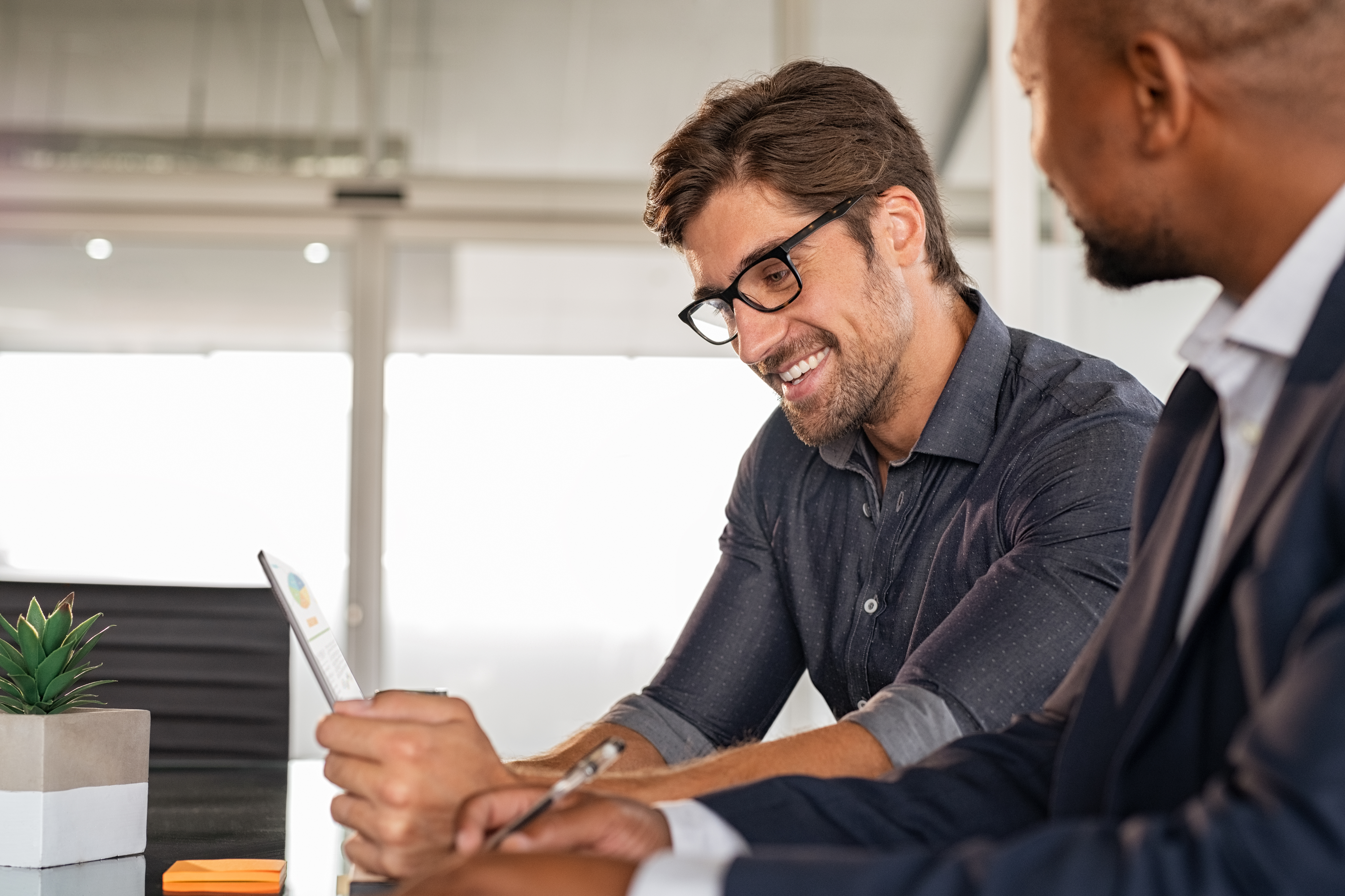 Two_Male_Business_Partners_Review_Data_on_a_Mobile_Device